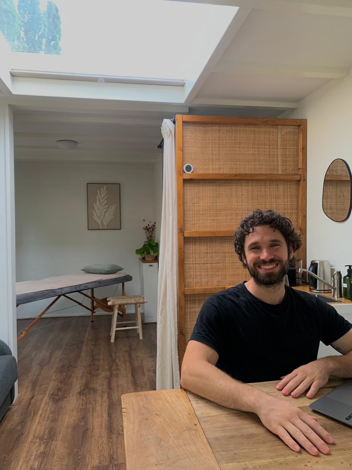 Fysiotherapeut Jeffrey van Mierlo aan tafel in zijn praktijk in Warnsveld